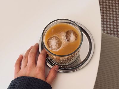 Hands resting comfortably on a wooden table surface
